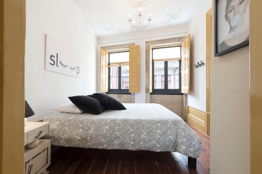 um quarto com uma cama e duas almofadas em BmyGuest - 156 Trindade House & Terrace em Porto