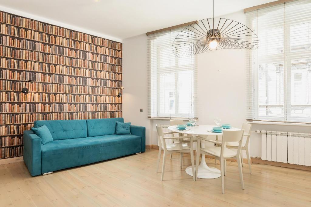 a living room with a blue couch and a table at Apartments Poznań Strzałowa by Renters in Poznań