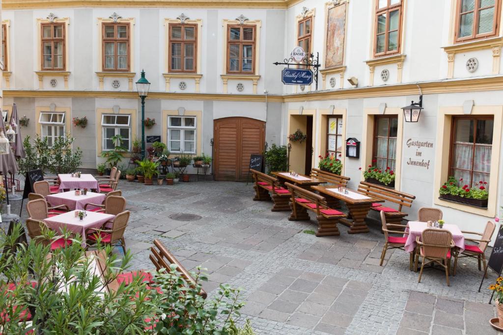 
a patio area with tables, chairs, tables and umbrellas at Gasthof Mang in Ybbs an der Donau
