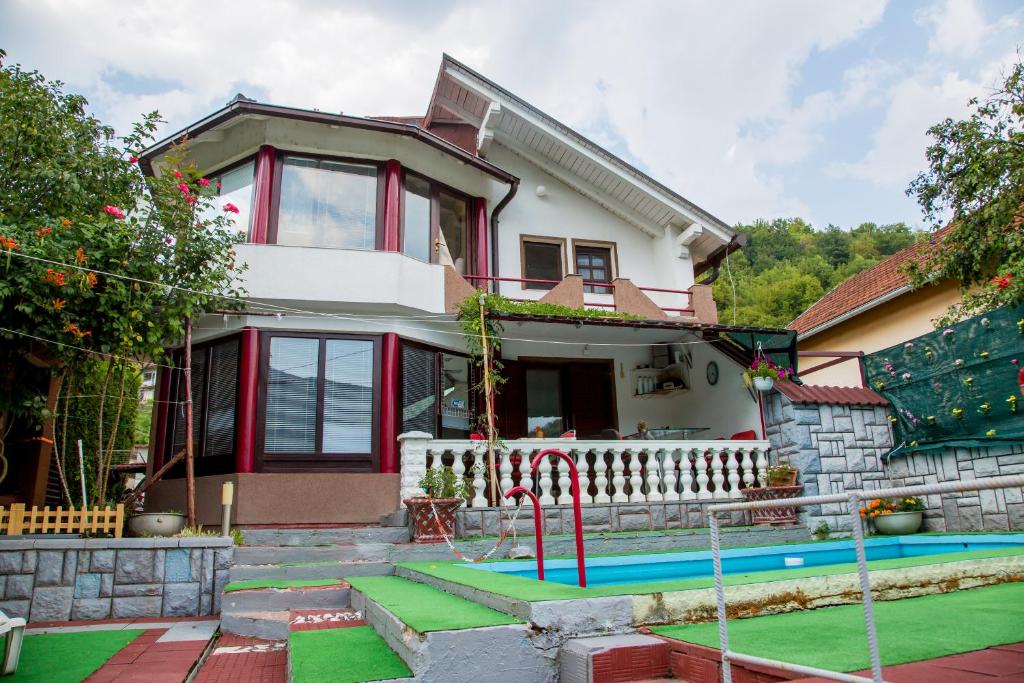 une maison avec une piscine en face de celle-ci dans l'établissement Villa Dino, à Kulen Vakuf