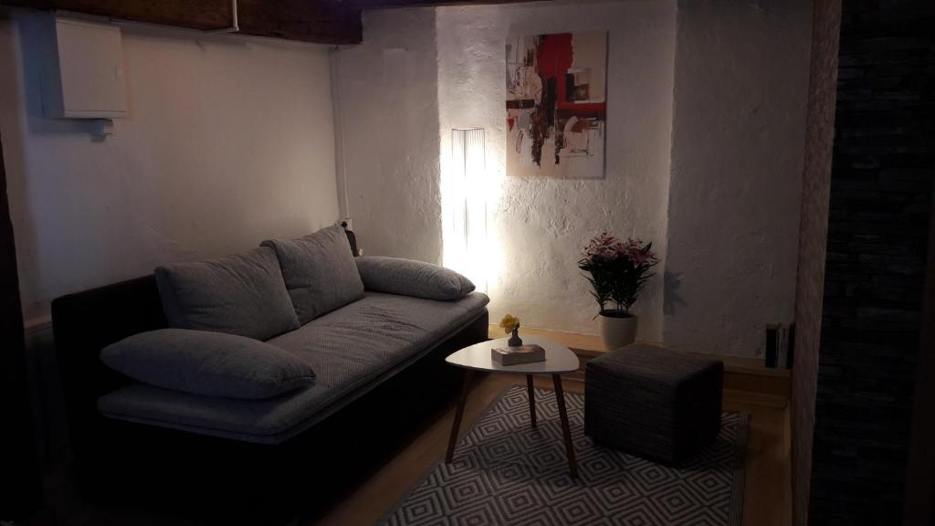 uma sala de estar com um sofá e uma mesa em Urige Ferienwohnung im Hafen Stralsunds em Stralsund