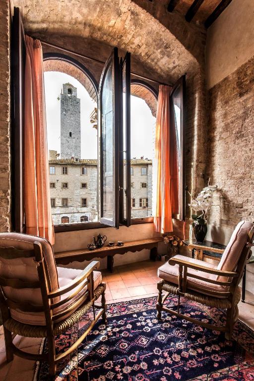 a room with two chairs and a large window at The Artists' Tower in San Gimignano