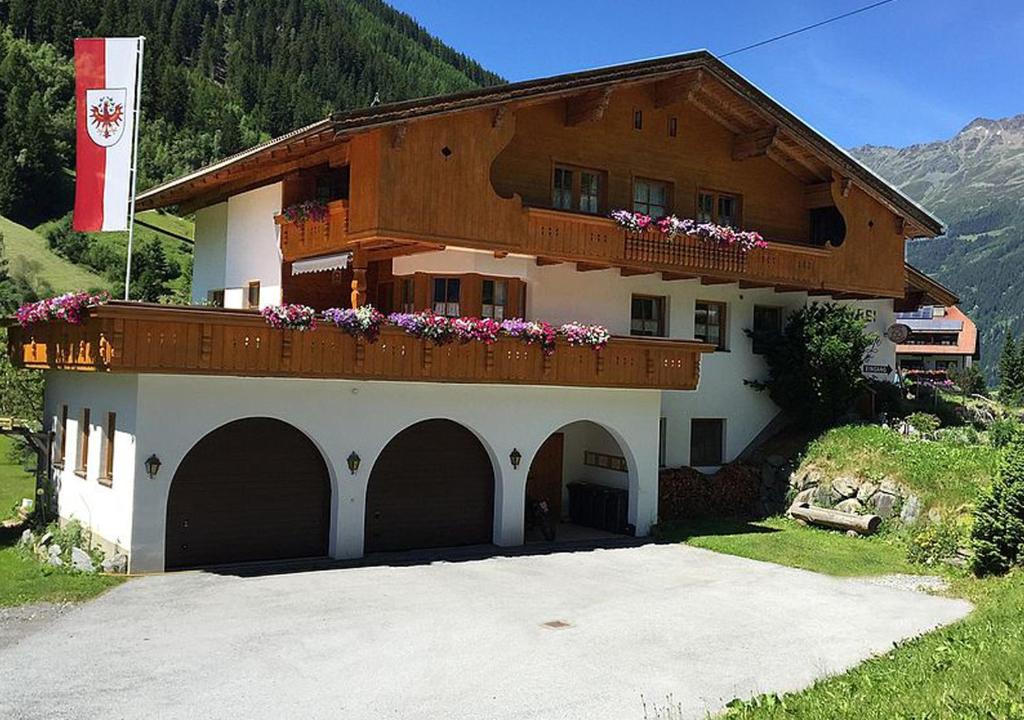 a building with a balcony with flowers on it at Apart Dorfbäck in Kaunertal