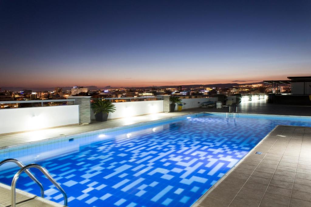 a swimming pool on the roof of a building at night at Eden Beach Apartment 611 in Limassol