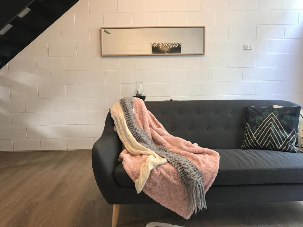 a blanket on a couch in a living room at The One @ Henley Beach in Grange