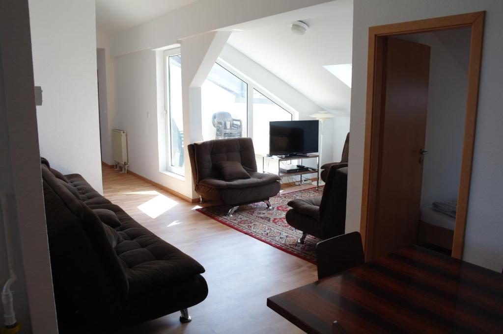 ein Wohnzimmer mit einem Sofa, 2 Stühlen und einem TV in der Unterkunft M M Central Apartments Gruppen, Handwerker und Monteure Budget in Berlin