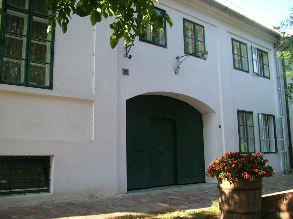 ein großes weißes Gebäude mit einer grünen Garage in der Unterkunft Hajós-ház in Szeged