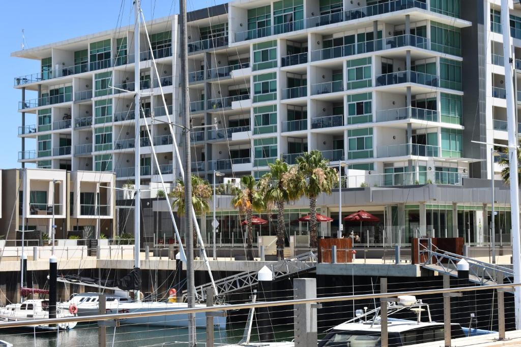 a large apartment building next to a marina at Breakwater Apartment in Port Adelaide