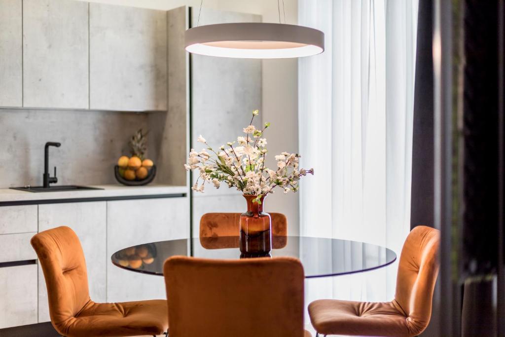 una mesa de comedor con sillas y un jarrón de flores en Monvi Luxury Suites en Split