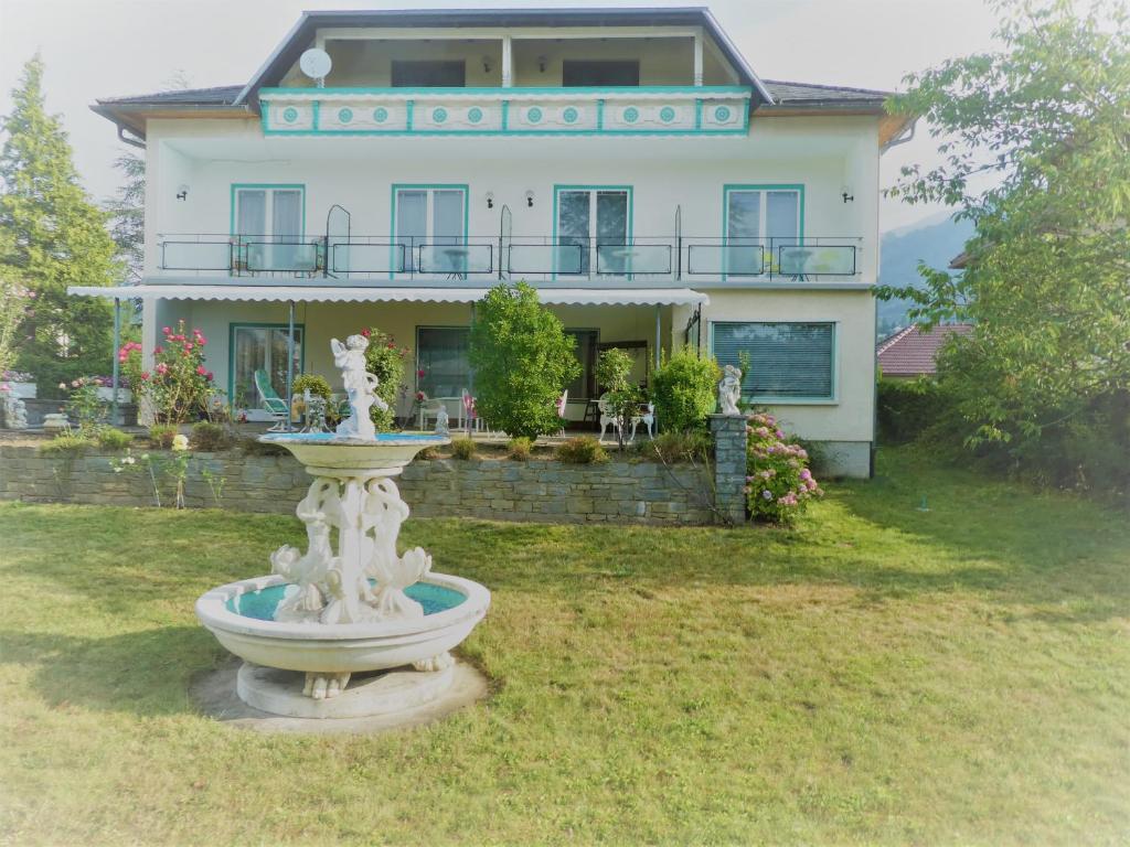 una casa grande con una fuente frente a ella en Villa Rauter en Seeboden