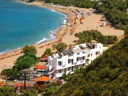 een uitzicht op een strand met parasols en een resort bij Bay Watch in Karpathos