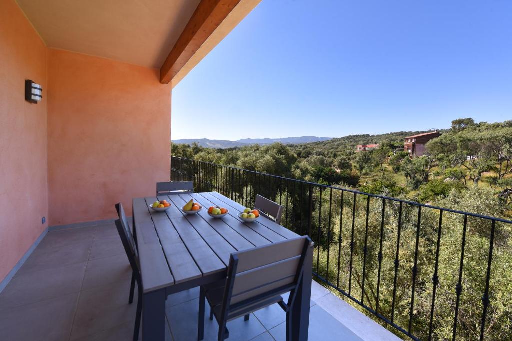 d'une table et de chaises en bois sur un balcon avec vue. dans l'établissement Sarl Valinco Locations, à Olmeto