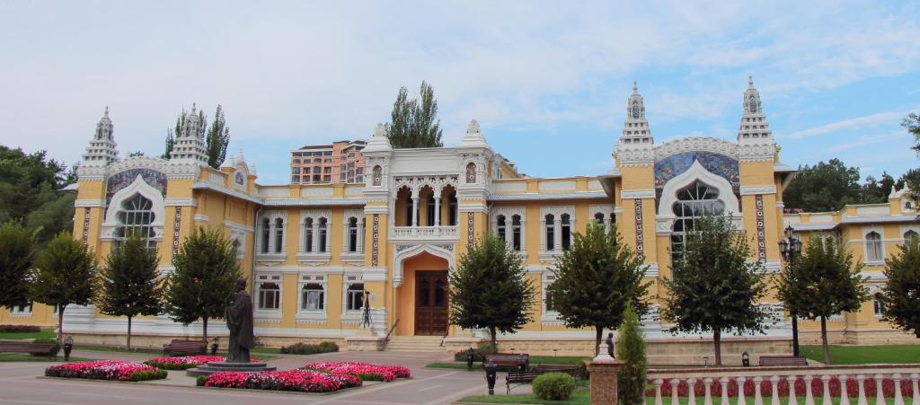 un gran edificio amarillo con flores delante en Санаторий Главные Нарзанные Ванны en Kislovodsk