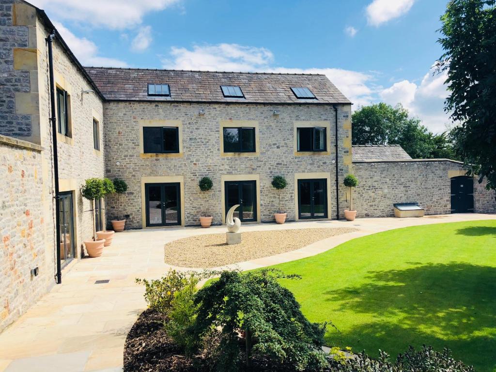 uma vista exterior para uma casa de pedra com um pátio em Millstream Mews em Bakewell