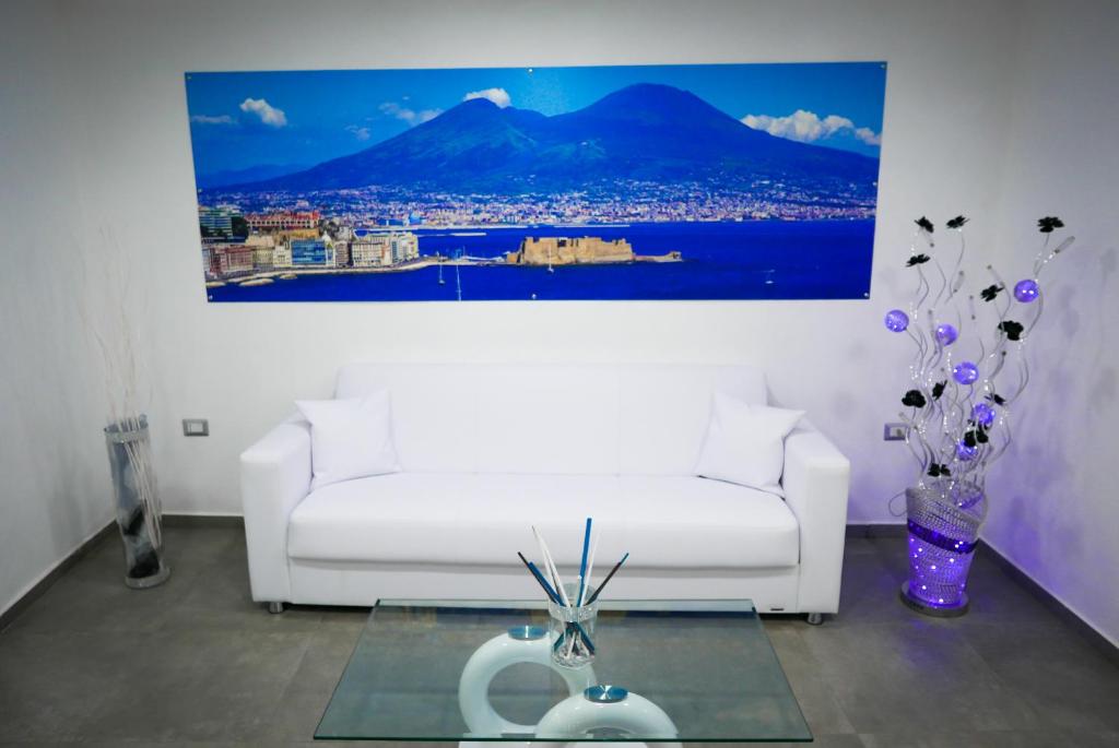 a living room with a white couch and a painting at Holiday House Tot&ograve; in Naples