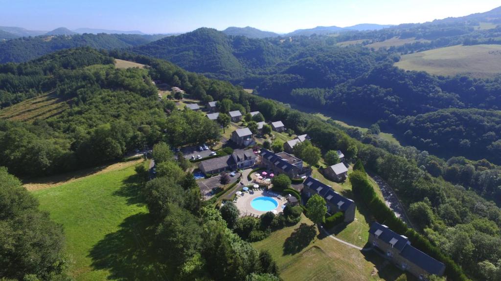 an aerial view of a house in the middle of a forest at VVF Cantal Salers Vendes in Bassignac