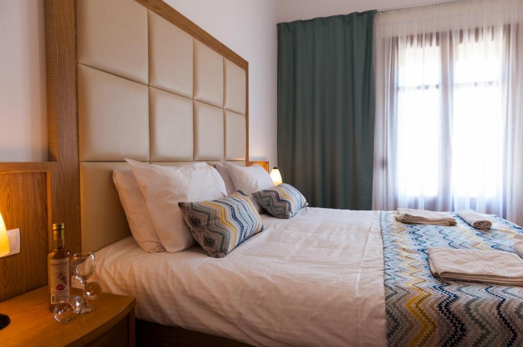 a bedroom with a large white bed with a window at Pallazzo Fortezza in Rethymno