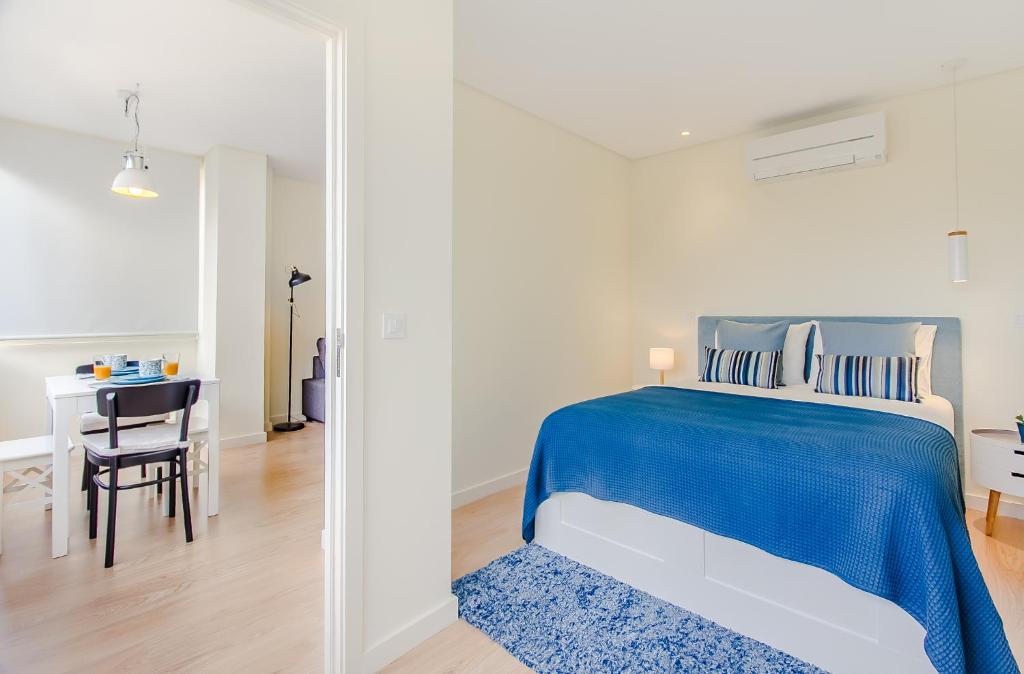 ポルトにあるTrindade Modern Flatのベッドルーム(青いベッド1台、テーブル付)