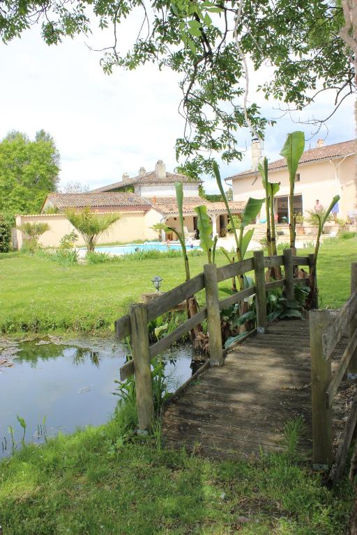 a wooden fence next to a pond in a yard at Clos Bernon in Libourne