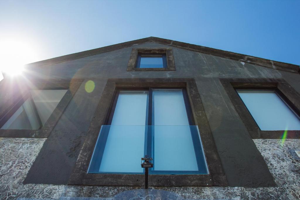 un edificio alto con tres ventanas a un lado. en Apartamentos Porto de Abrigo, en São Vicente