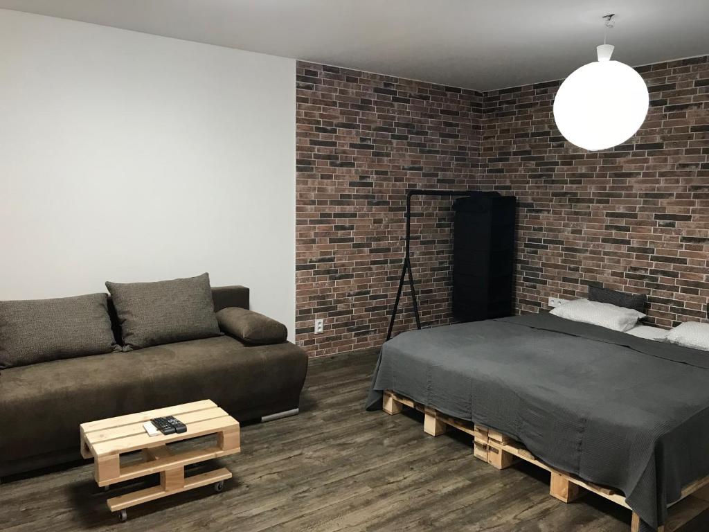 a bedroom with a bed and a brick wall at Apartment Kubo in Vranov nad Topľou