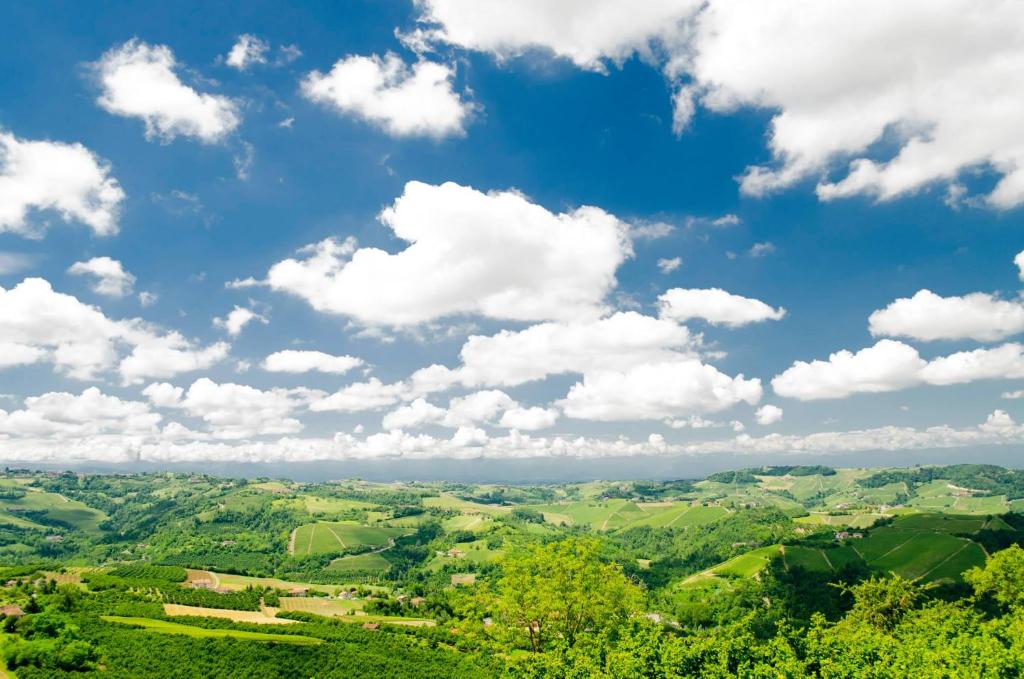 a view of a green valley under a blue sky with clouds at B&B La Buonora in Sinio