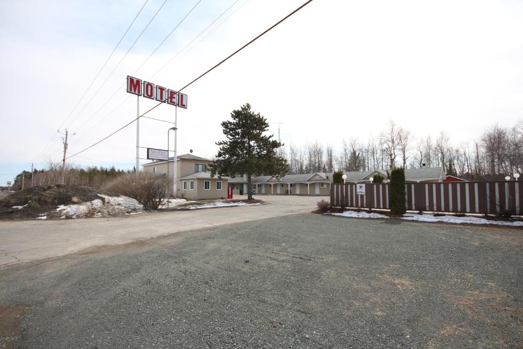 Une rue vide avec un panneau de motel en arrière-plan dans l'établissement Motel Marie-Dan, à Sainte-Eulalie