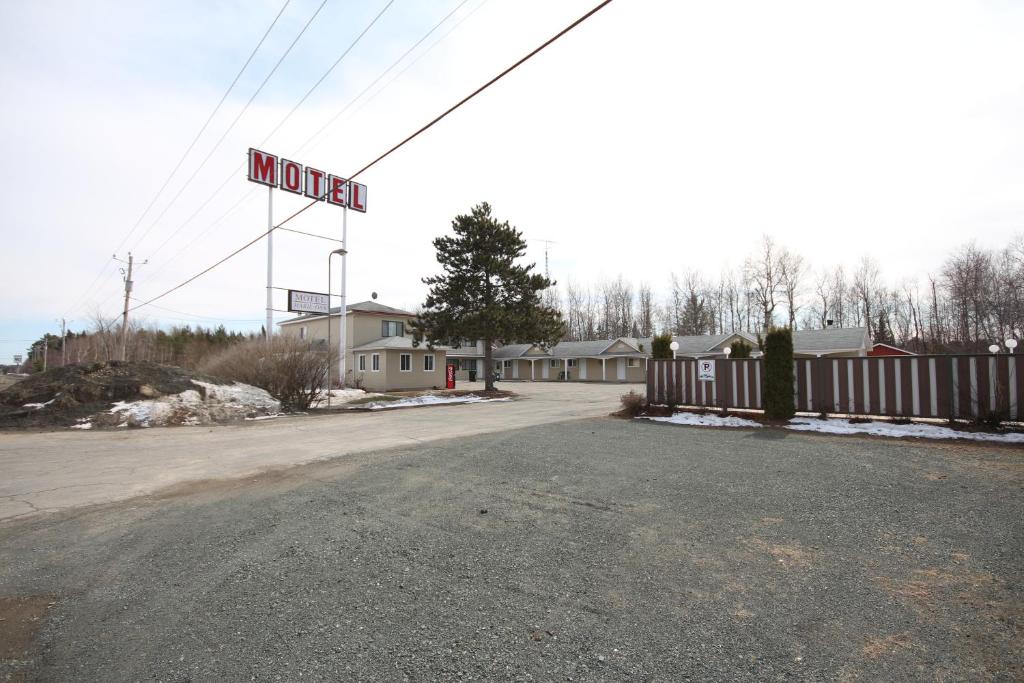 an empty street with a motel sign in the background at Motel Marie-Dan in Sainte-Eulalie