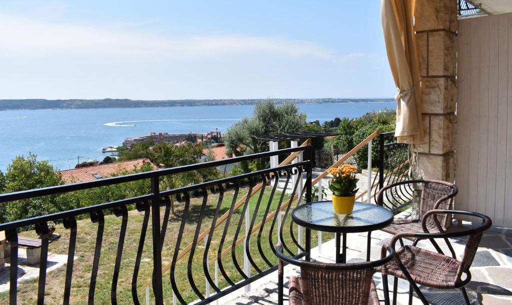 una mesa en un balcón con vistas al agua en Appa Apartments, en Portorož