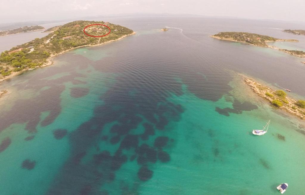 an island with a red clock in the water at Thalassokipos in Vourvourou