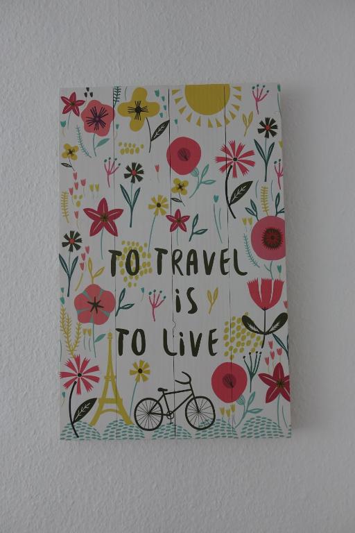 un foglio con fiori e un cartello che dice di viaggiare è vivere di Ver-Reiss-t a Korlingen