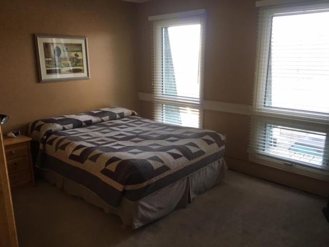 - une chambre avec un lit et 2 fenêtres dans l'établissement Laura's Lodge, à Saskatoon