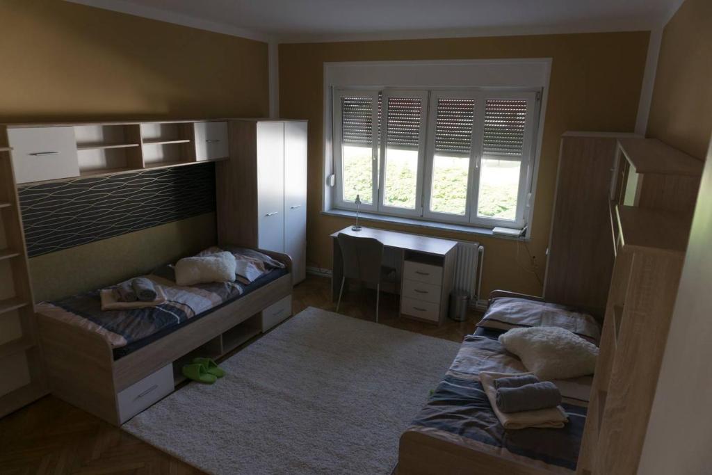 a small bedroom with two beds and a desk at Trendy apartmant in city in Maribor