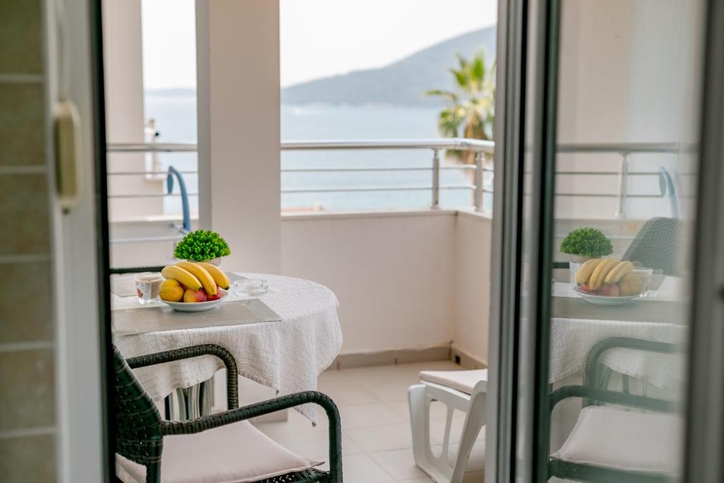 a table with a bowl of fruit on a balcony at Apartment Stella Maris in Herceg-Novi