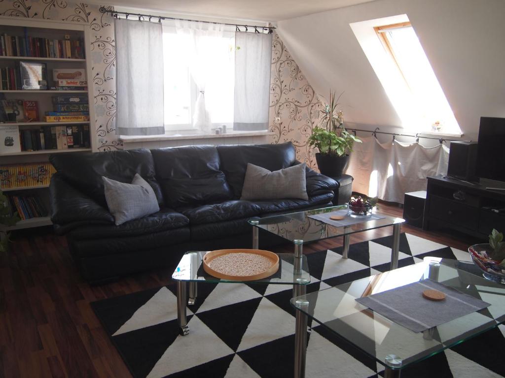 a living room with a black couch and a table at Fewo Sonnenschein in Bremerhaven