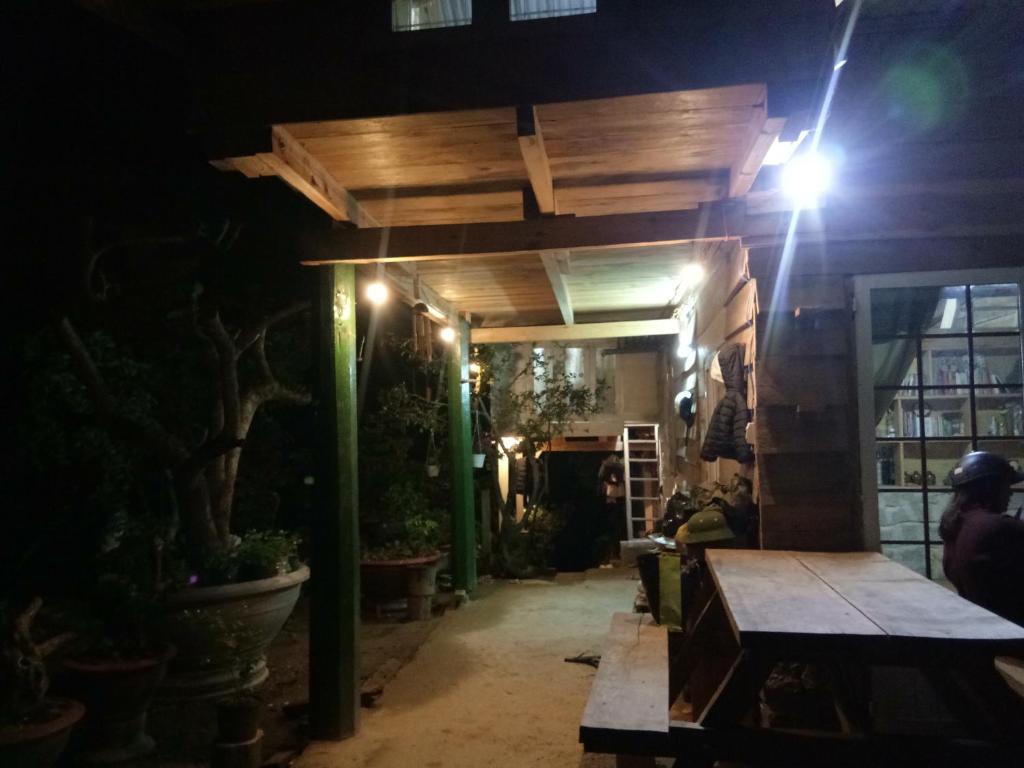 um pátio à noite com uma mesa e algumas plantas em Homestay Da Blah em Da Ðeum (2)