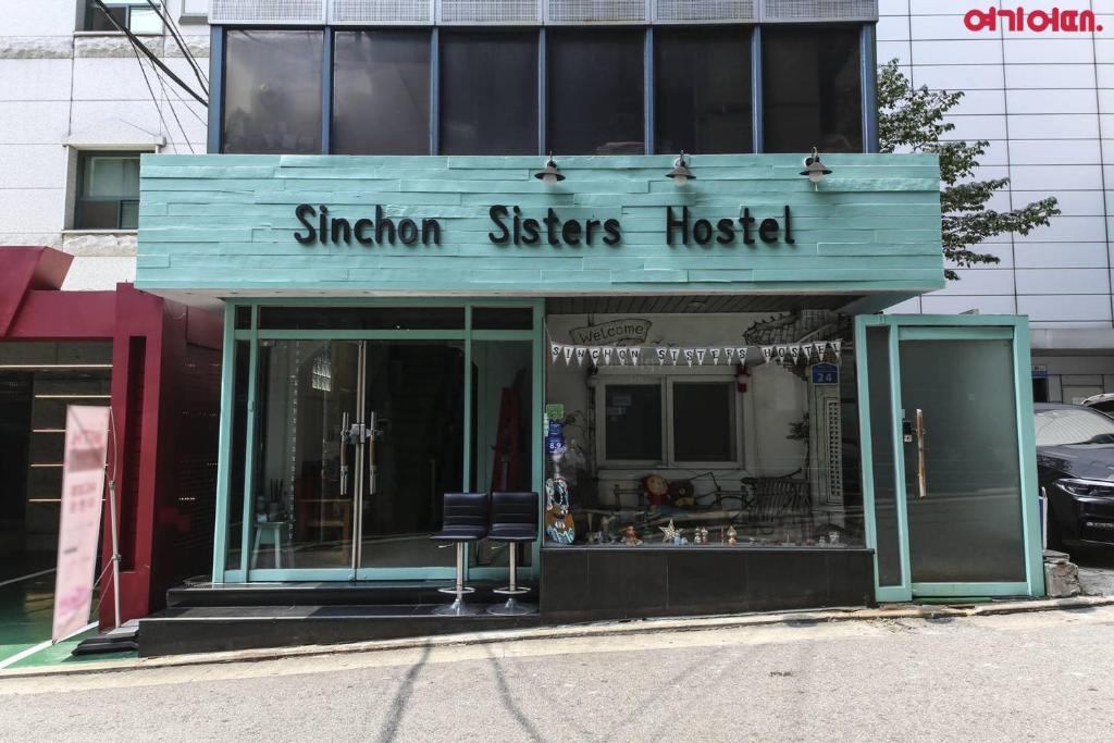 a storefront of a shimer sisters hospital on a street at Sinchon Sisters Hostel in Seoul