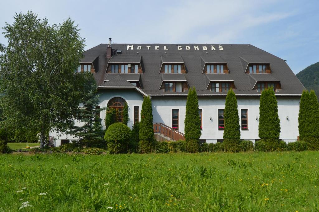 a hotel surrounded by trees and a green field at Motel Gombáš in Hubová
