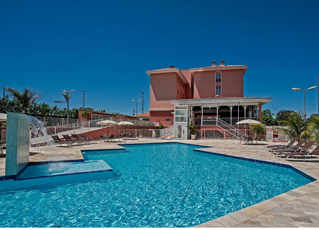 a swimming pool in front of a building at The Hill Hotéis Executive in São Carlos