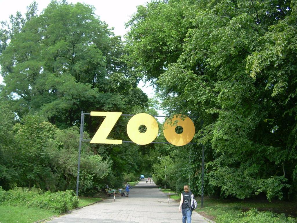 ワルシャワにあるP&O Apartments Namyslowskaの動物園の看板を持って歩く者