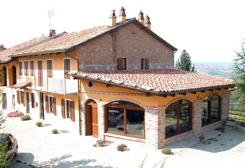 un grand bâtiment avec des fenêtres et un toit dans l'établissement La Briccola, à Diano dʼAlba