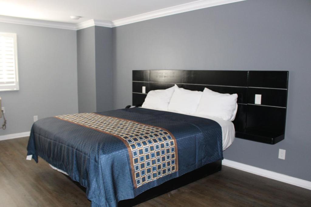 a bedroom with a large bed with a black headboard at ERTH INN by AGA Los Angeles in Los Angeles