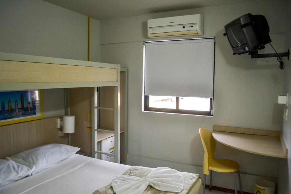 a bedroom with a bed and a desk and a window at EXPRESSO R1 HOTEL in Maceió