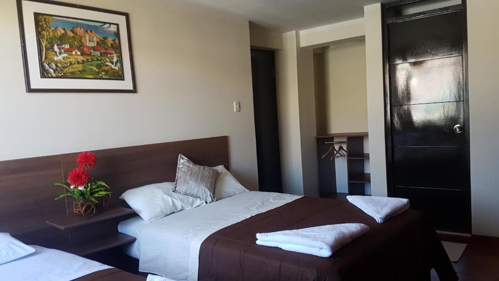 1 dormitorio con 2 camas y puerta negra en Cálido Hostal, en Moquegua
