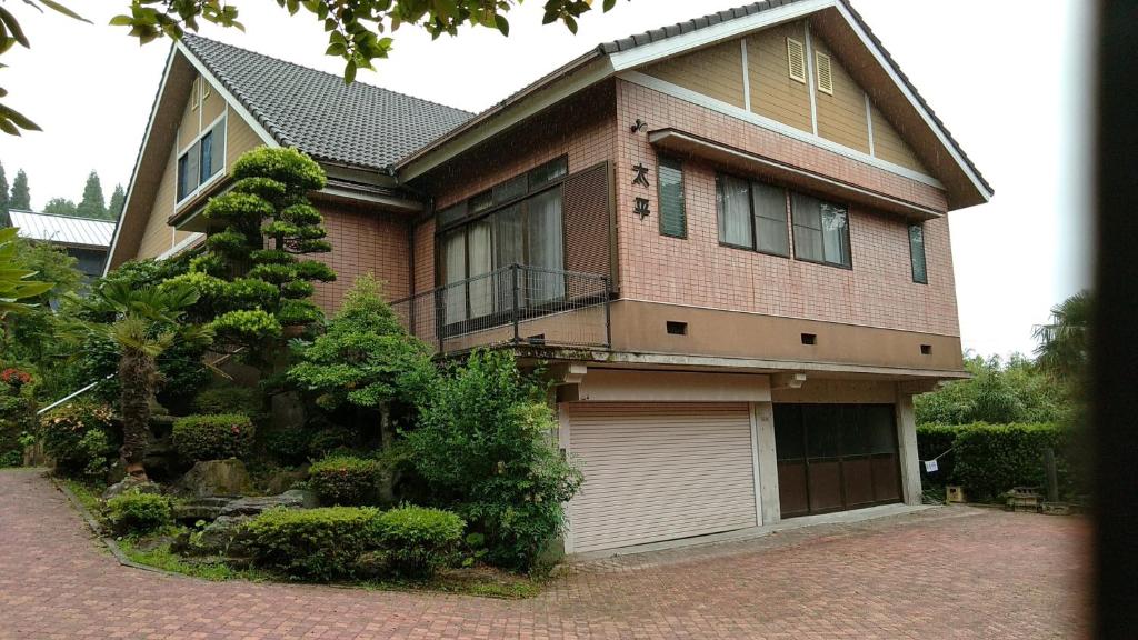 una gran casa de ladrillo con garaje en Guesthouse Taihei, en Aso