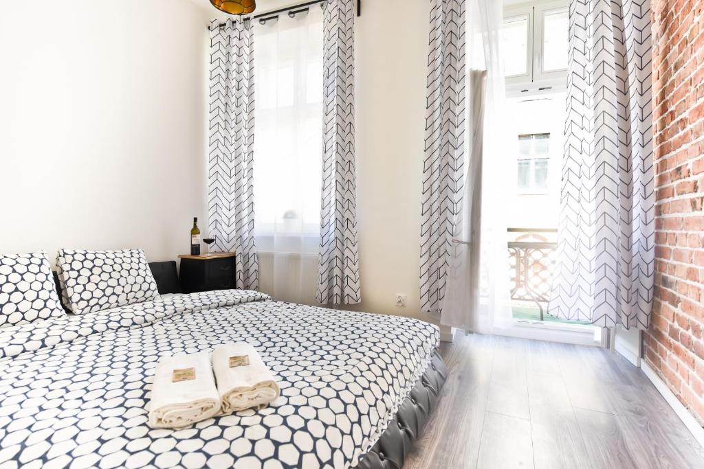 - une chambre avec un lit et des chaussons dans l'établissement Metropolis Apartment, à Toruń