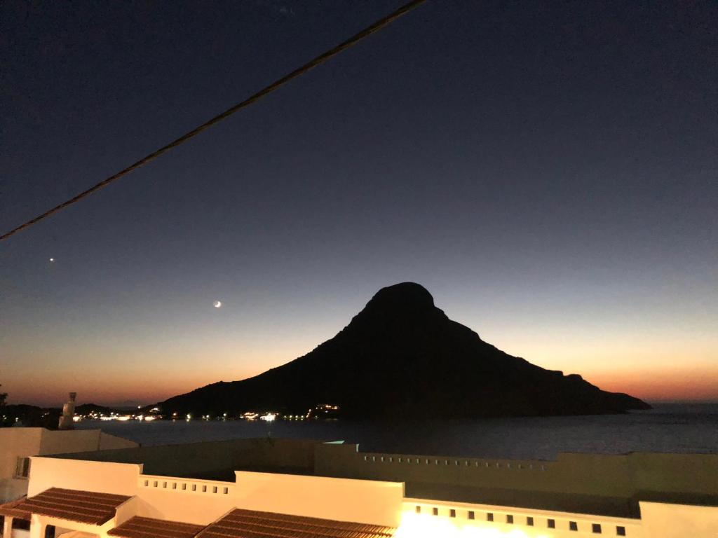 a view of a mountain in the ocean at night at Nikolas Studios in Masouri