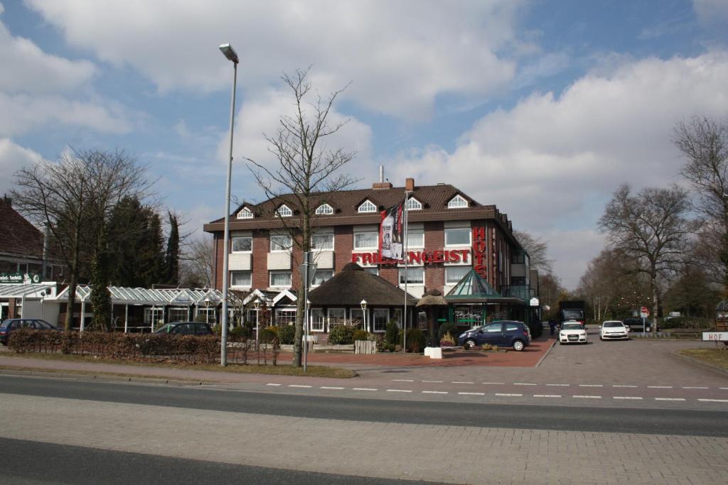a building on a street with cars parked in front of it at Hotel Friesengeist in Wiesmoor
