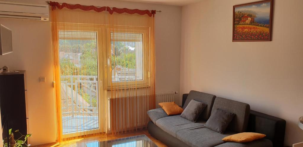 a living room with a couch and a window at City Inn Apartment in Osijek