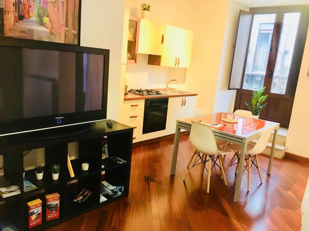 a living room with a dining room table and a television at Giupy Home in Catania